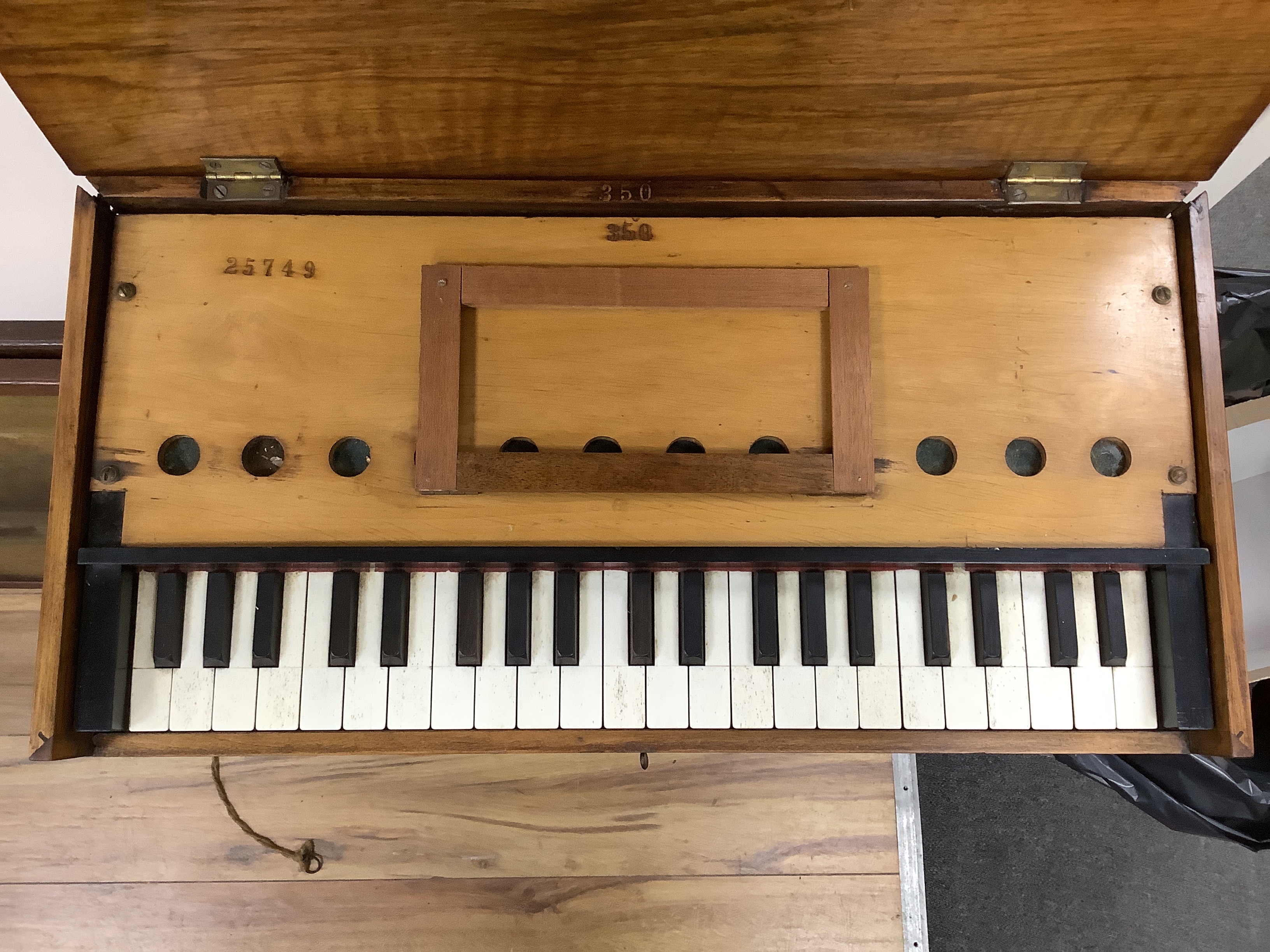 A small early 20th century walnut cased harmonium, with single bellows action, on fixed turned stand, width 59cm, height 81cm